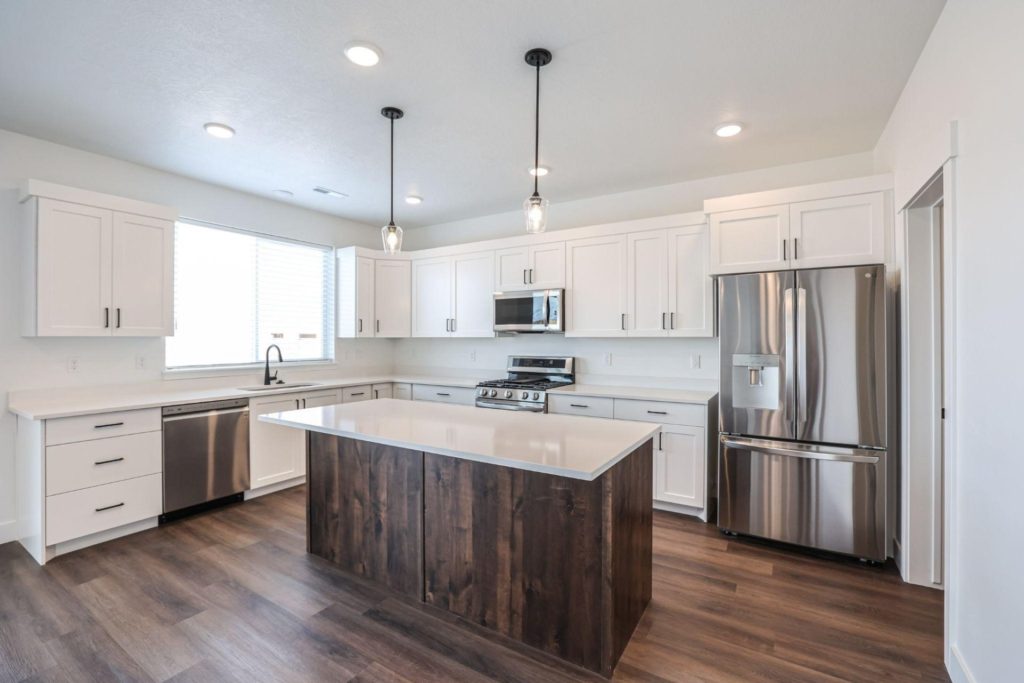 The Savannah floor plan hosting beautiful white cabinets with a statement, dark-stained island.